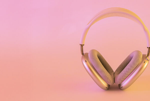 stylish product photograph of some headphones against a peach coloured background