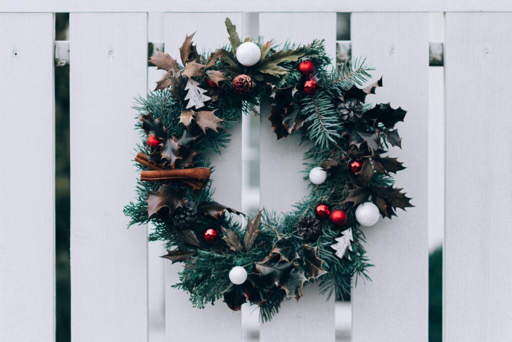 A Christmas wreath on a white fence