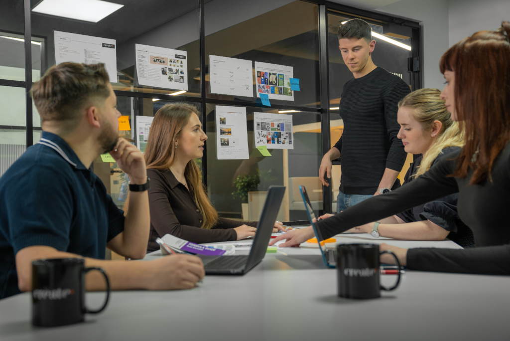 The Create8 brand team gathered around a table and working on a rebrand projects