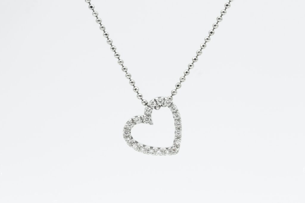 Product photography of a diamond heart necklace against a white background