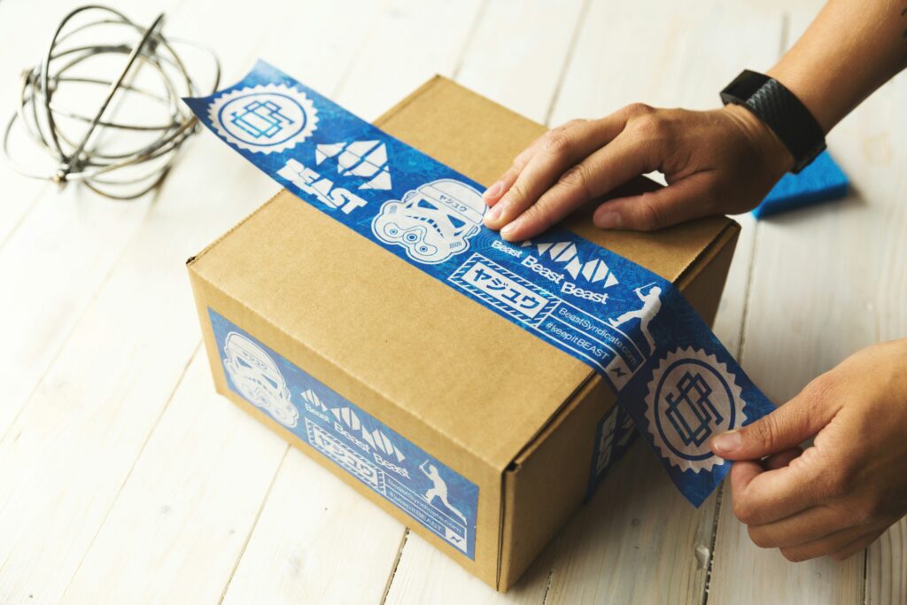 Man putting tape on a cardboard parcel