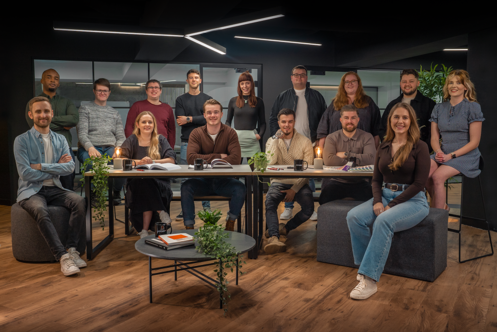 The Create8 eCommerce Web Development Team gathered around a table