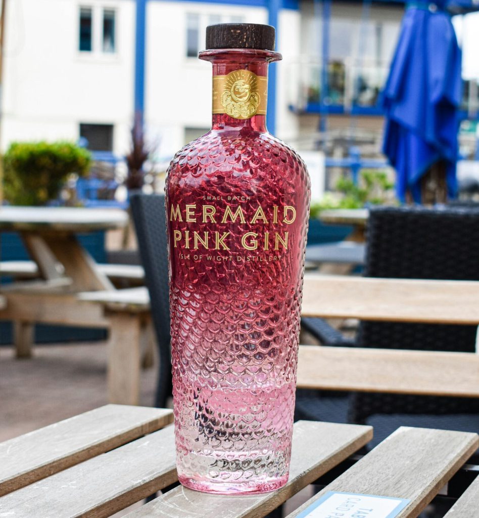 Mermaid pink gin bottle on a pub table
