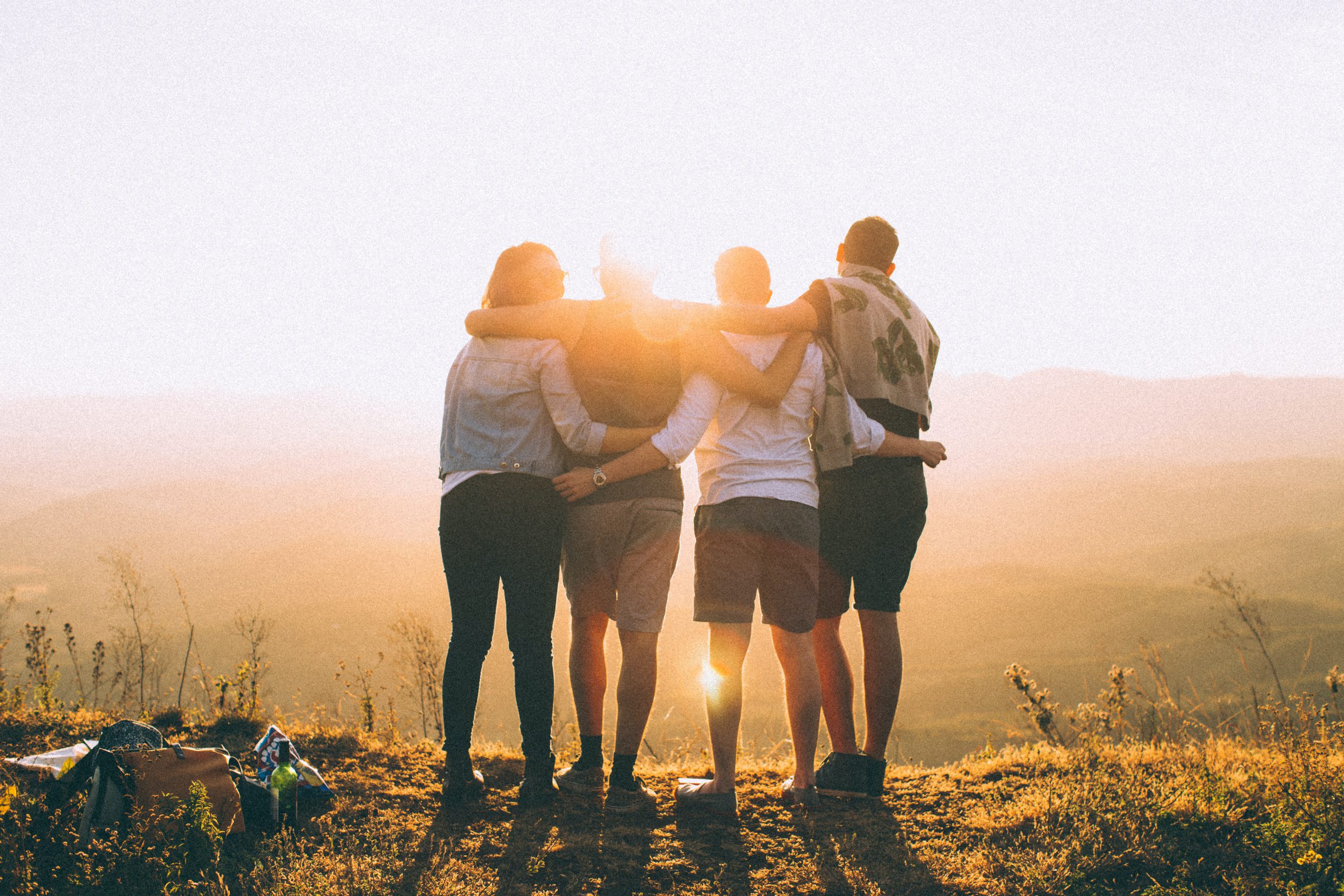 Gen Z group huddled together and looking at a sunset