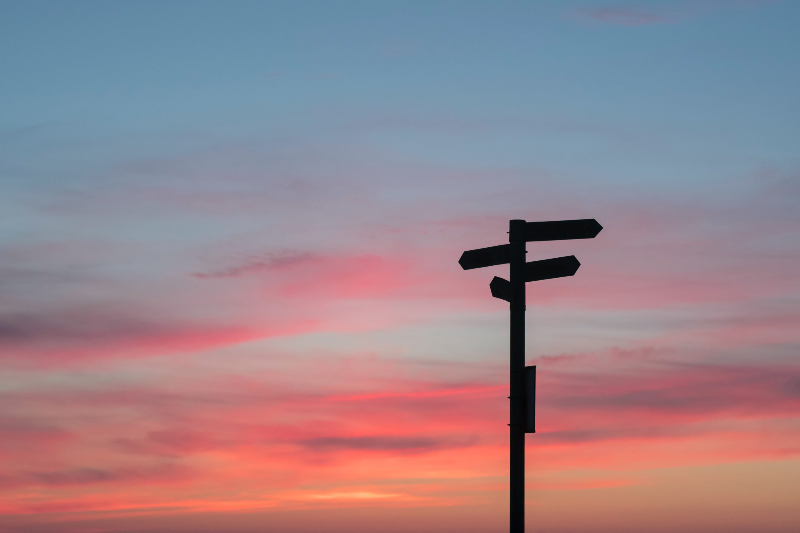 sign at a crossroads against a sunset background
