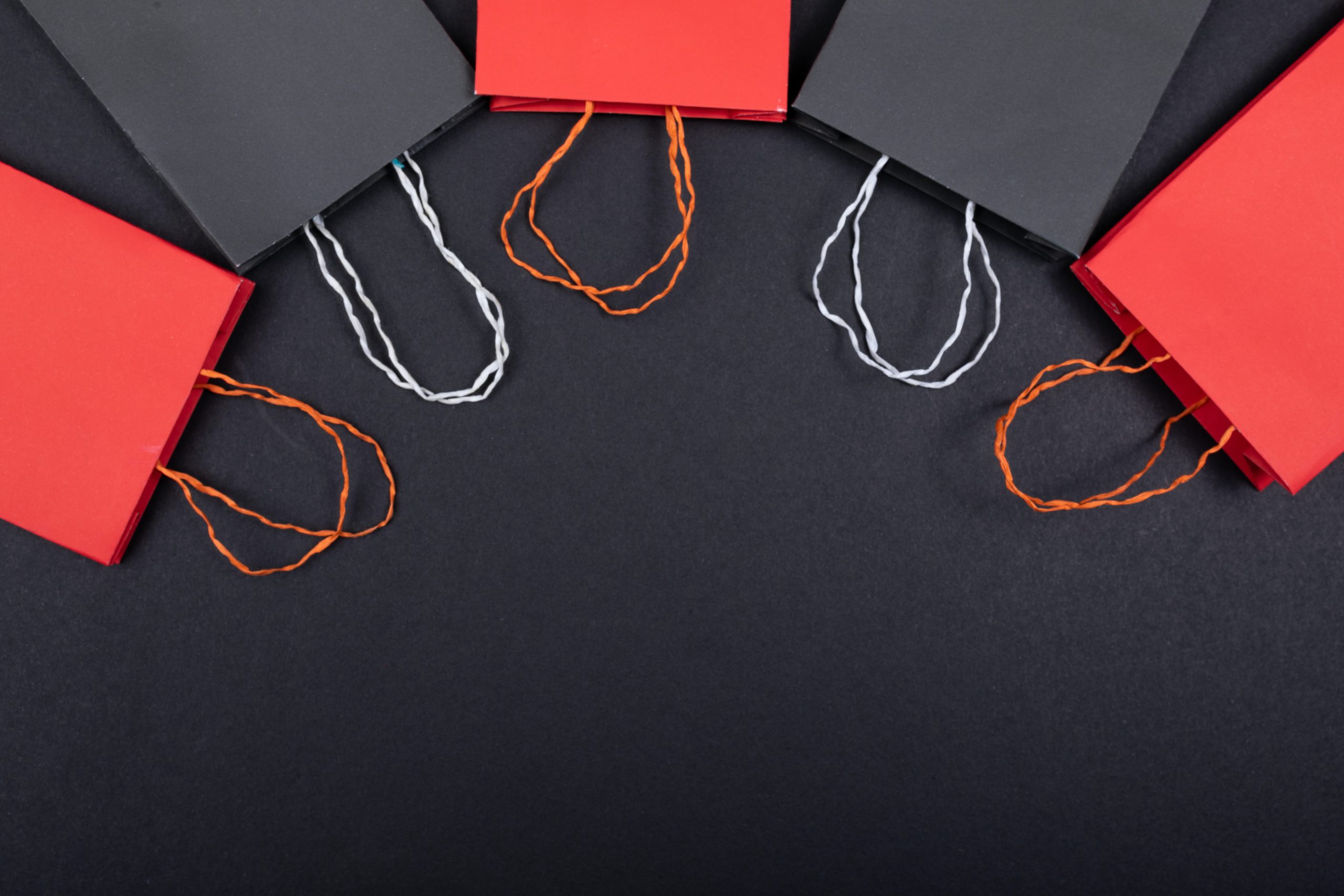 Black and red subscription gift bags against a black background